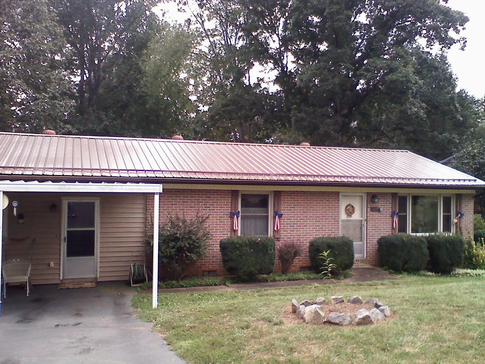 Bronze metal roof and carport on a brick ranch home — Roof Repair work by our crew in Donalsonville